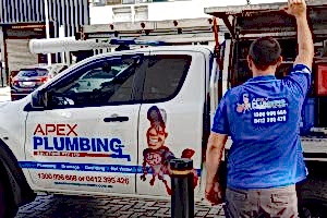 A professional plumber standing beside a truck labeled "Apex Plumbing Solutions Pty Ltd," preparing for a job. This image emphasizes the importance of knowing when to call a professional for issues such as how to unclog a toilet without a plunger.