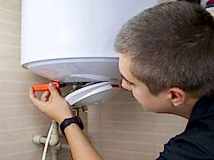 Technician repairing a water heater, addressing issues that can lead to low hot water pressure.